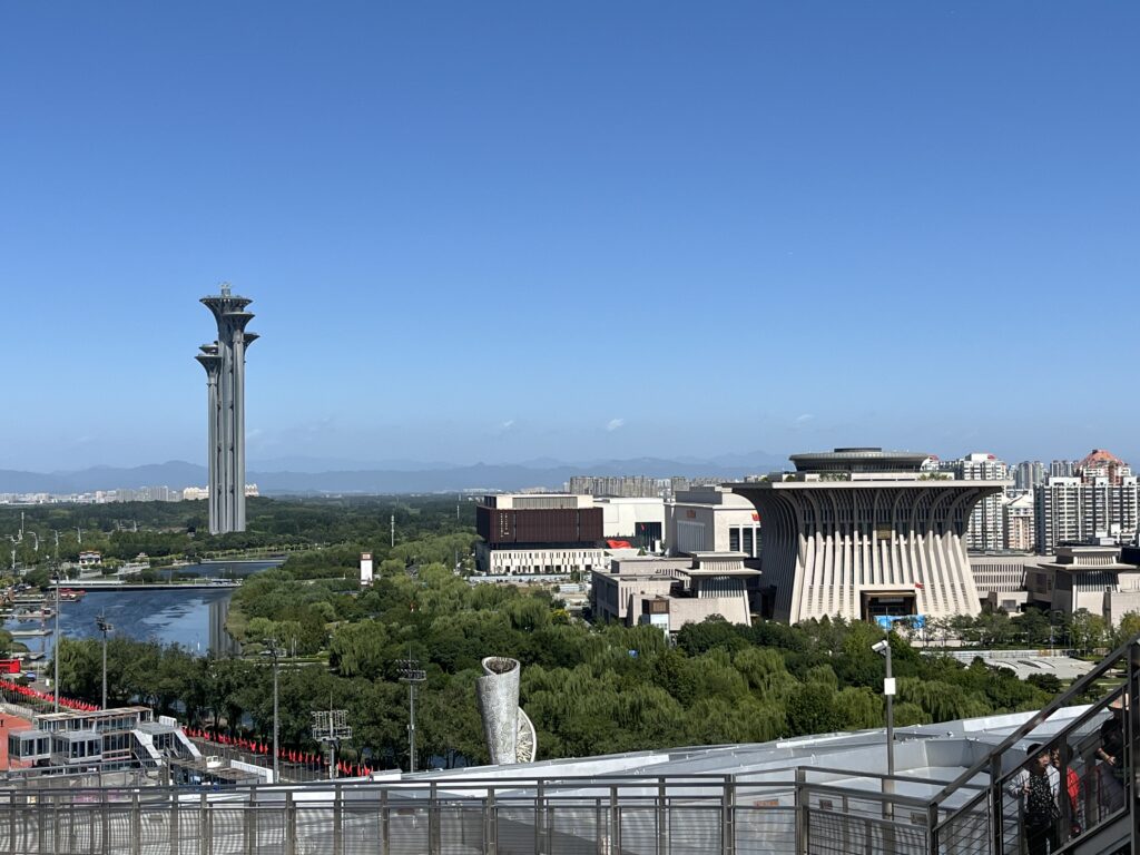 Blick vom "Nest" auf Peking - im Vodergrund die Olympische Flagge als Gebäude